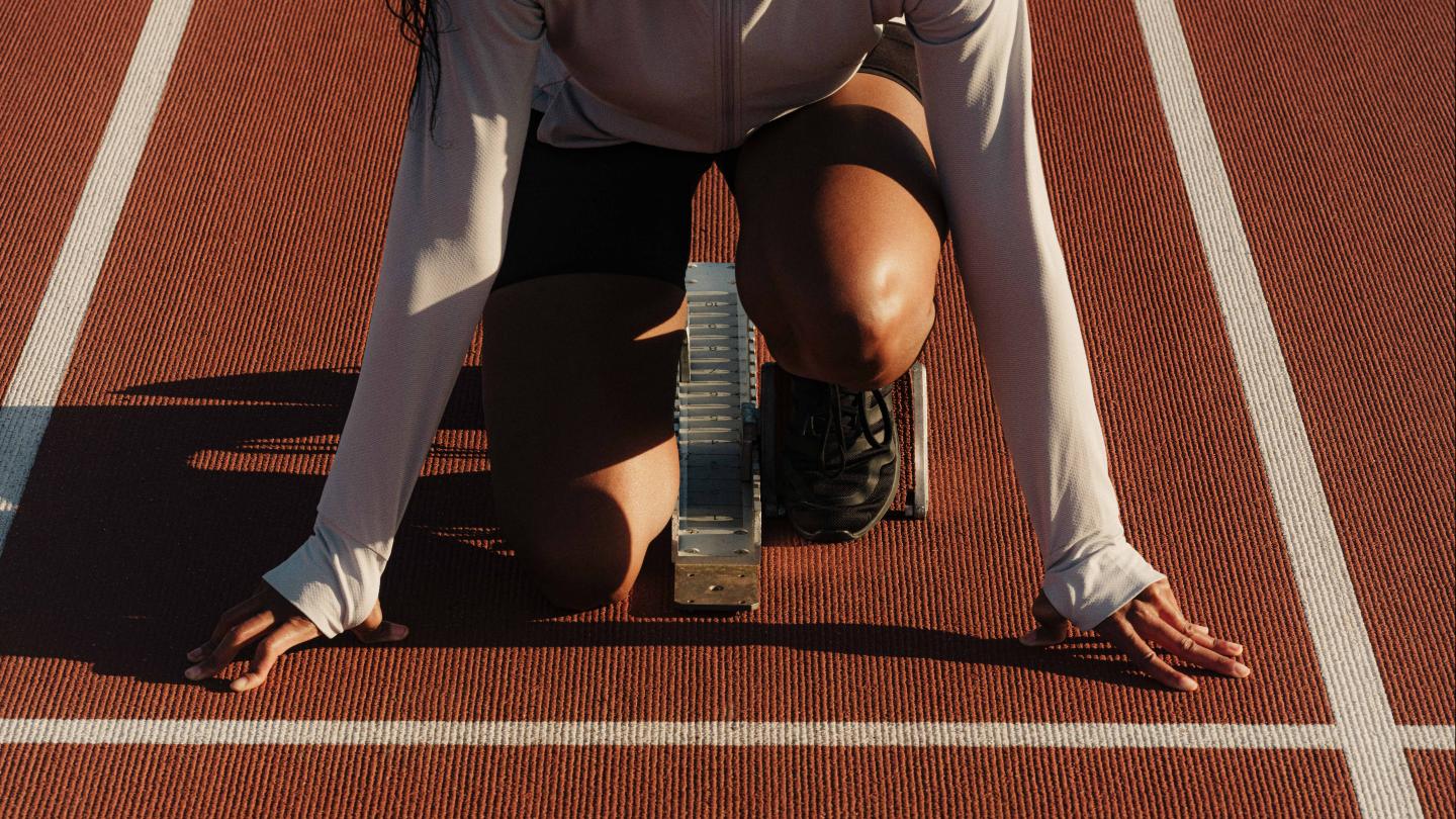 Runner on set position on the starting blocks.