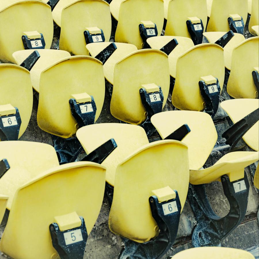 Multiple rows of yellow stadium seats