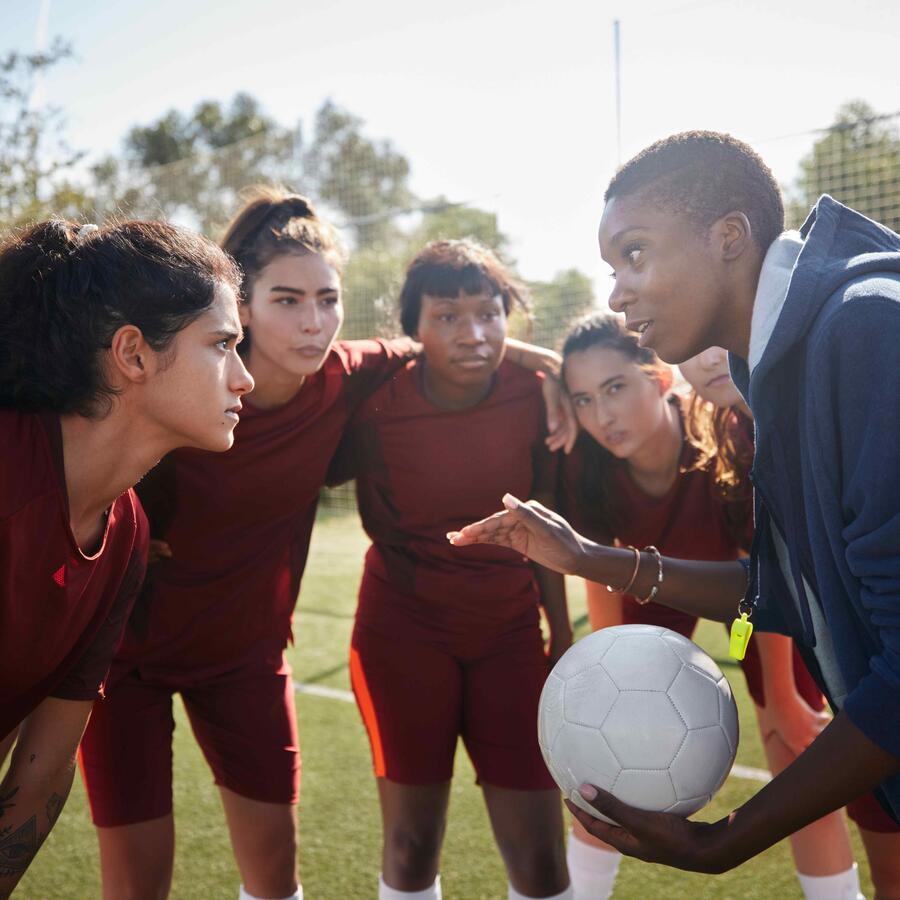 A soccer coach speaking to their team