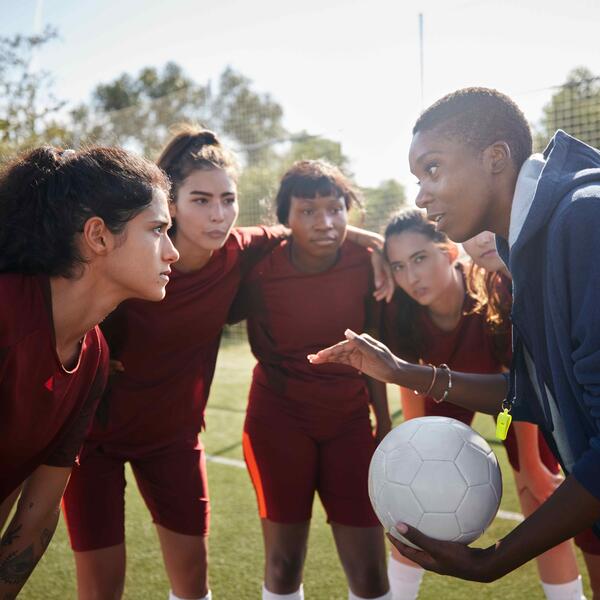 A soccer coach speaking to their team