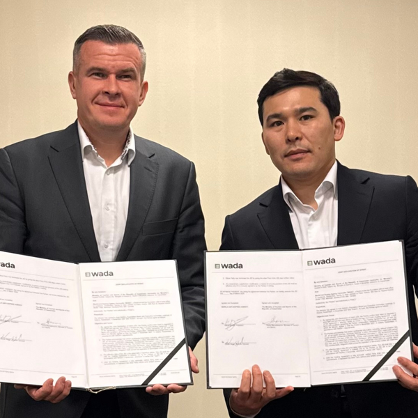 WADA President, Witold Bańka holding signed agreement of additional contribution with a representative of the Government of Kazakhstan